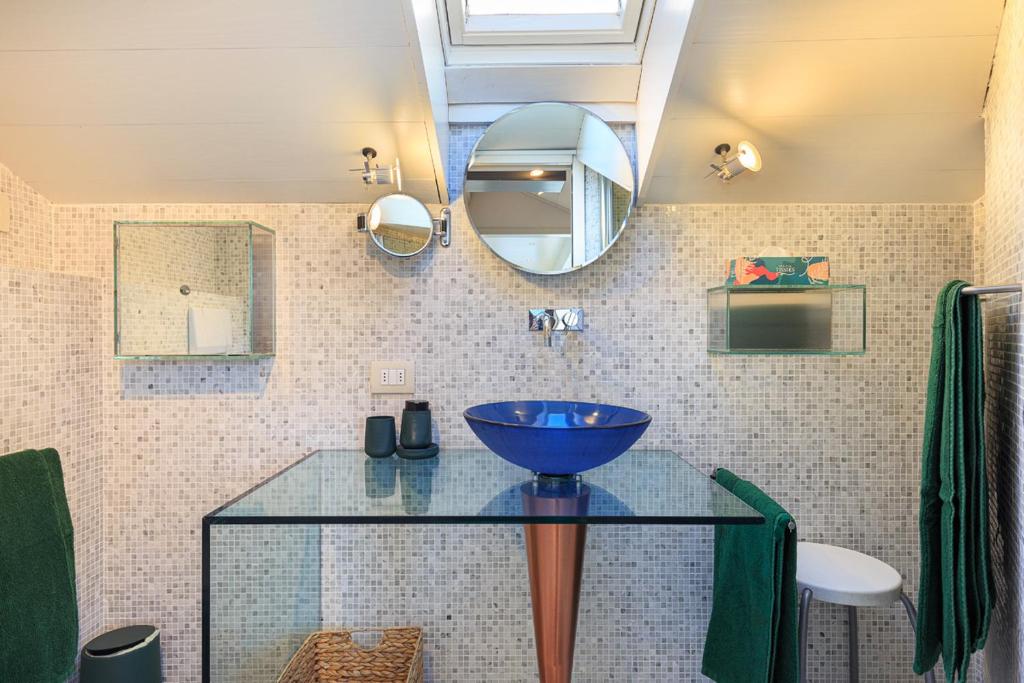 a bathroom with a blue bowl on a glass table at Casa Giacomo in Arona