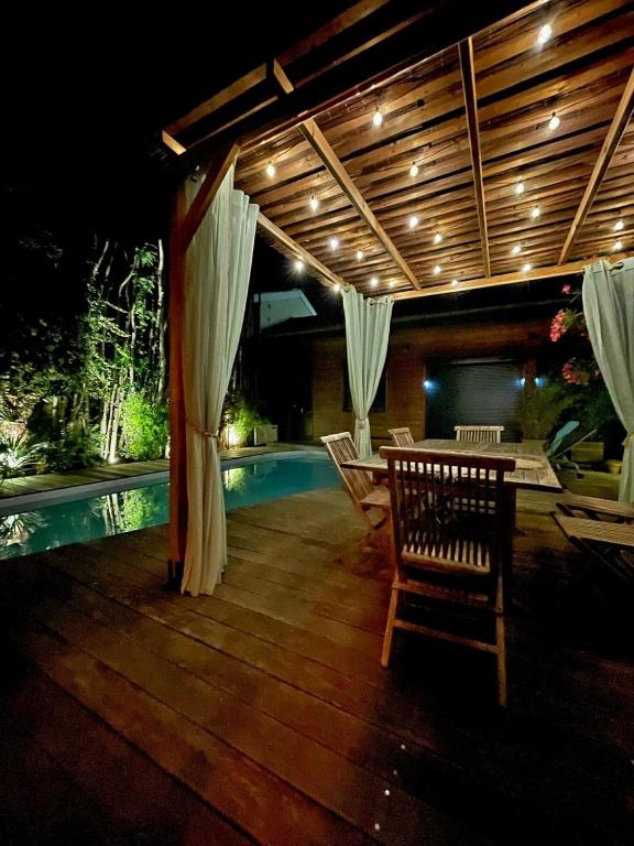 un patio avec une table et des chaises à côté d'une piscine dans l'établissement Charmante maison de ville en pierre avec piscine, à Eysines