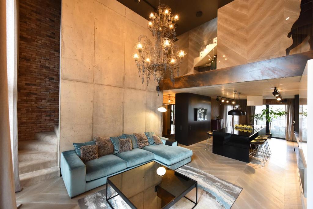 un soggiorno con un divano e un lampadario di Premium Loft Apartment a Palanga