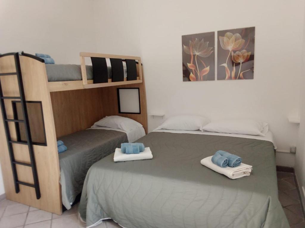 1 dormitorio con 2 literas y toallas. en RoMare Boutique inn, en Marina di Cerveteri