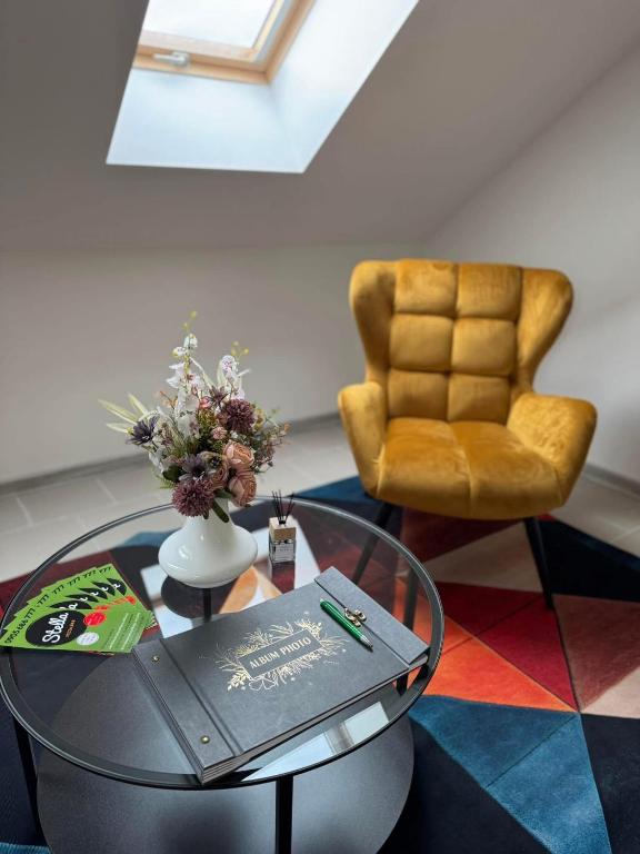 a living room with a glass table and a chair at Nostalgia restaurant & pension in Rimavská Sobota