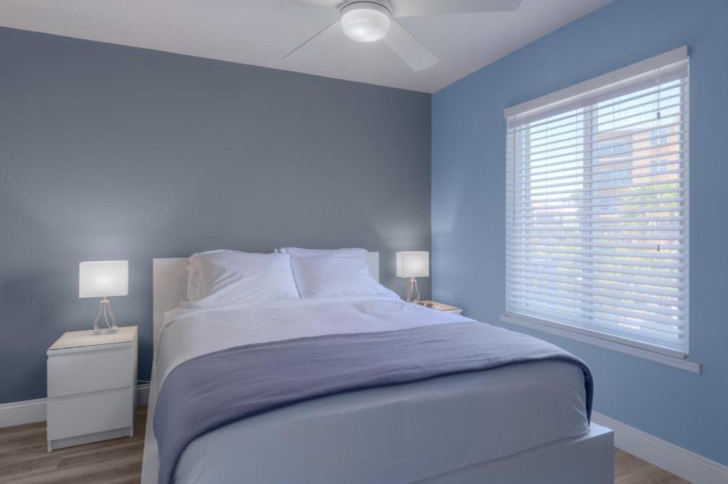 a blue bedroom with a bed and a window at A Wave From It All Oceanview 2Nd Level Patio in Jacksonville Beach