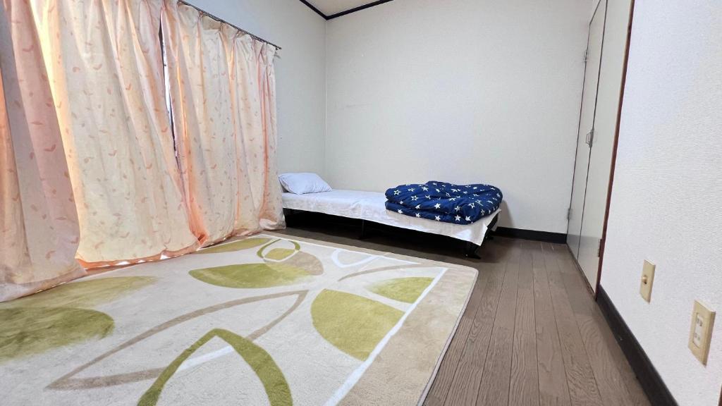 a small room with a bed and a window at Apartment 202 Joso Japan in Shimo-tsuma