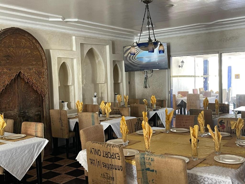 a dining room with tables and chairs and a chandelier at Issablanca in Oualidia