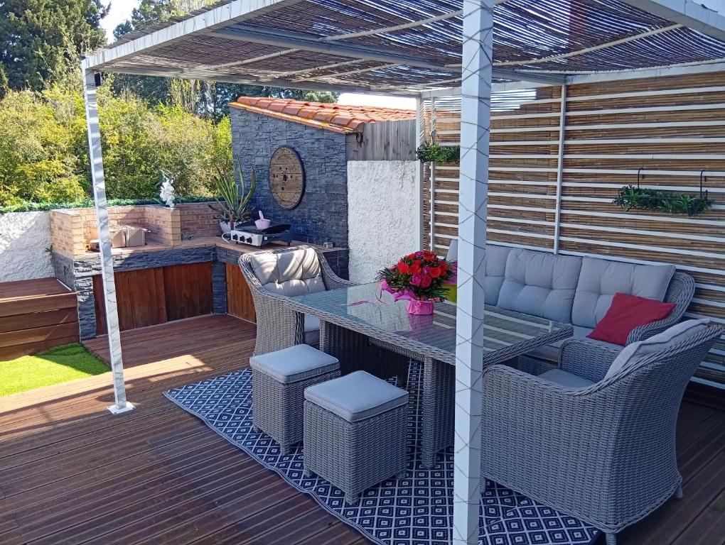 un patio avec une table et des chaises sur une terrasse dans l'établissement Maison au calme située à 10 minutes des plages, à Montescot
