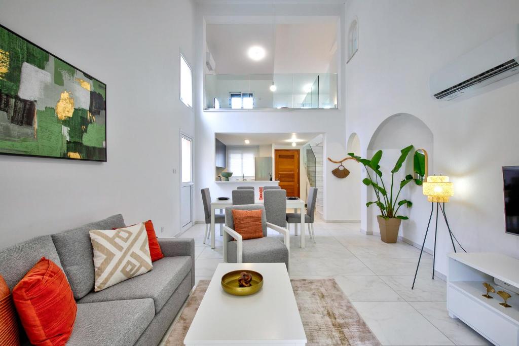 a living room with a couch and a table at Aphrodite Gardens Stunning Villa by VICHY Holidays in Paphos