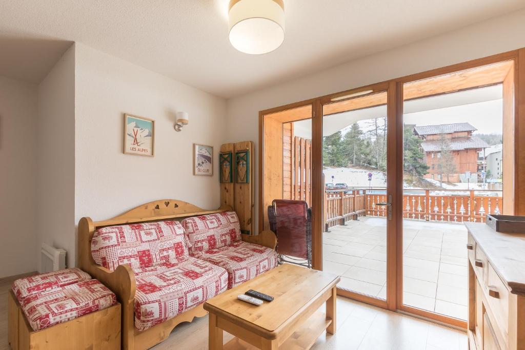 un salon avec un canapé et une table dans l'établissement Le Piolet - Vue montagne proche pistes, à Saint-Étienne-en-Dévoluy