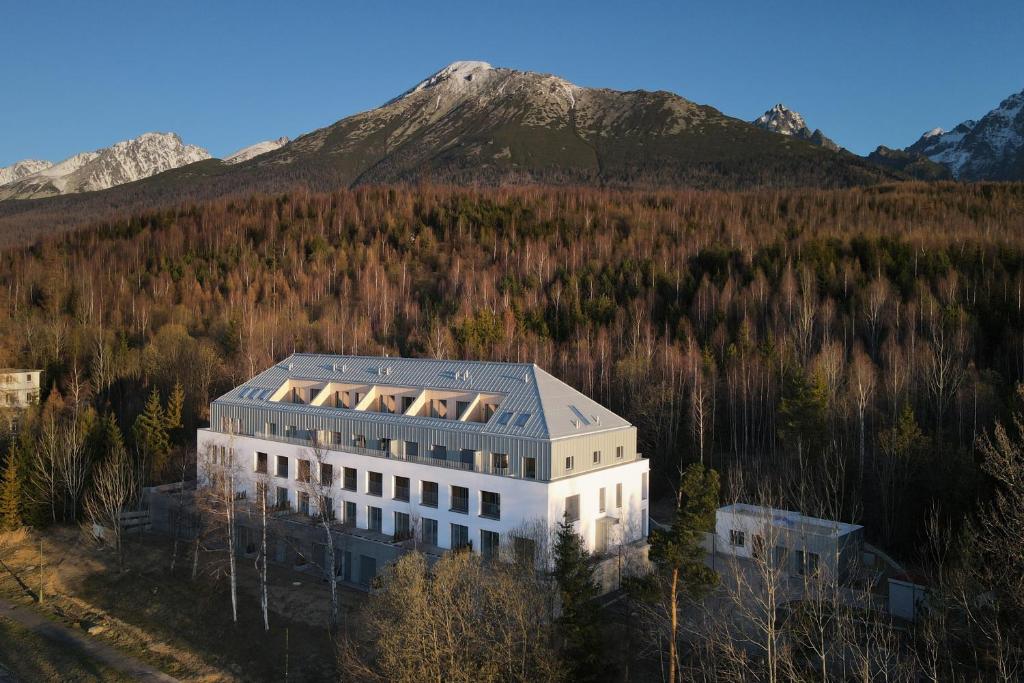 an aerial view of a building with a mountain in the background at TATRYSTAY Lebenski Premium Apartments in Vysoké Tatry