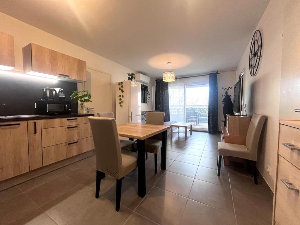 une cuisine et une salle à manger avec une table et des chaises dans l'établissement Bel appartement avec terrasse en bord de mer, à Mauguio
