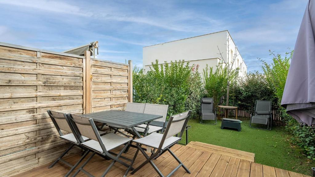 une table et des chaises sur une terrasse avec une clôture dans l'établissement La Dune N64 Villa 3P6, à Sérignan