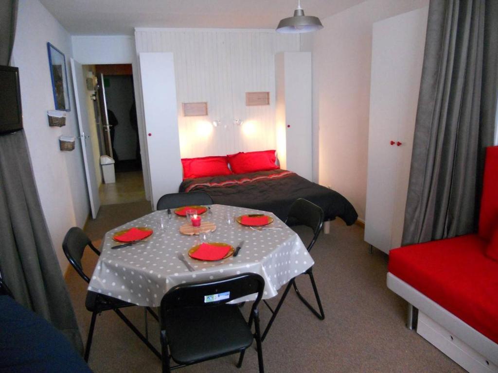 Cette chambre comprend 2 lits et une table avec des oreillers rouges. dans l'établissement Studio 4 pers, pied des pistes, cuisine équipée, balcon sud - FR-1-404-92, à La Mongie