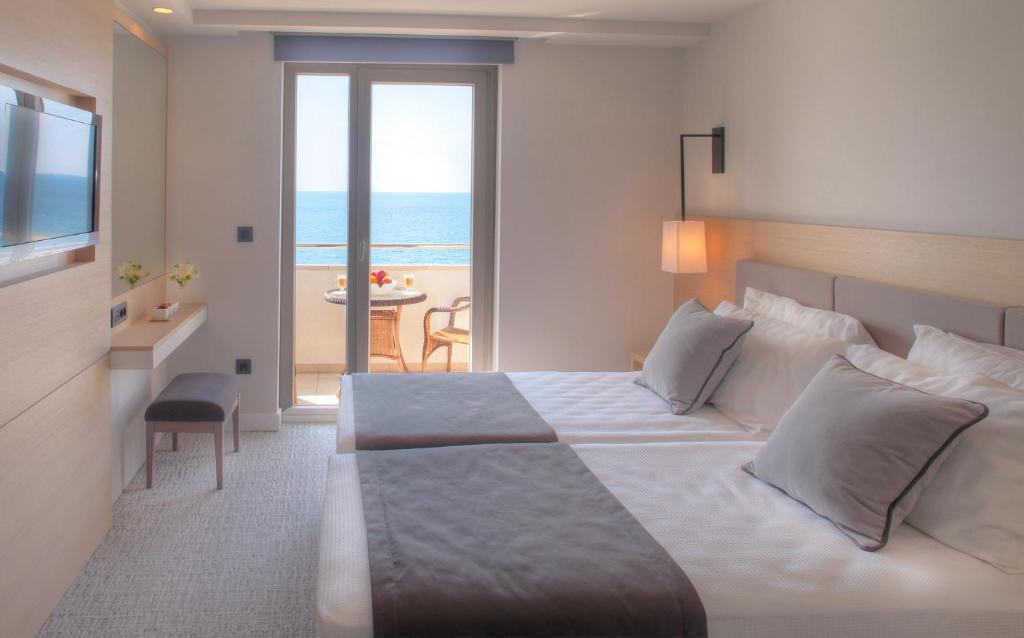 a bedroom with a bed and a view of the ocean at Royal Neptun Hotel in Dubrovnik