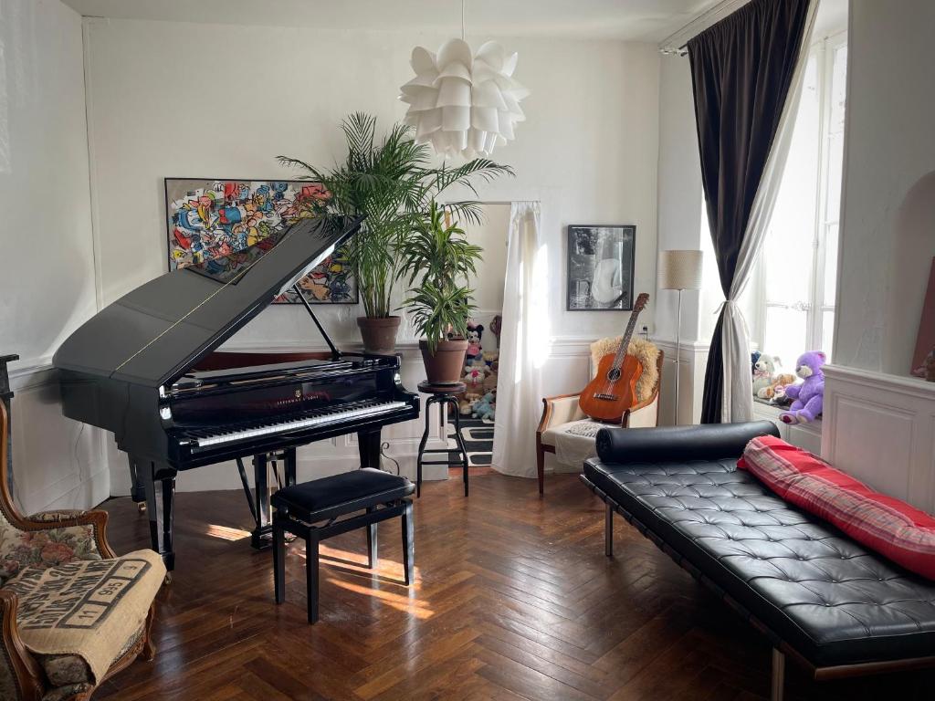 un salon avec un piano et un canapé dans l'établissement Artist Residence - courtyard, terrace, Grand Piano, à Siran