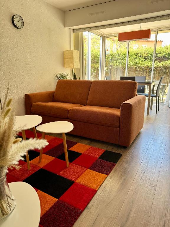 - un salon avec un canapé et des tables sur un tapis dans l'établissement L'ocre du Sud - 6 pers - Histoire de clés, au Cap d'Agde