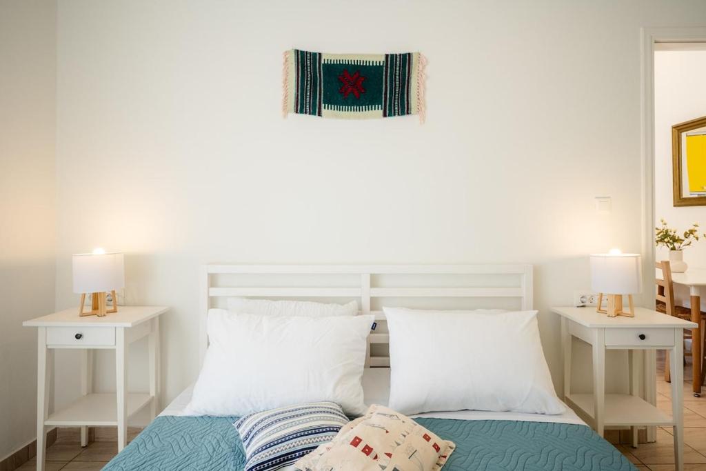 een slaapkamer met een bed met twee witte tafels bij Bella Apartment in Chania