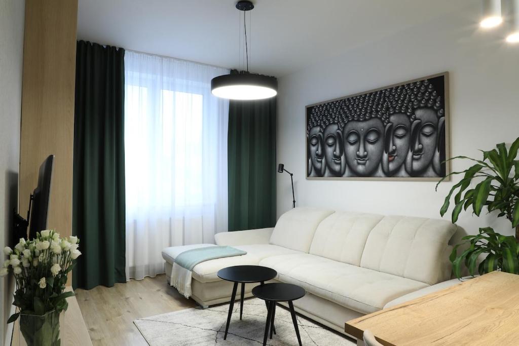 a living room with a white couch and a table at 2i apt with terrace, new building, Lužná 26 in Bratislava
