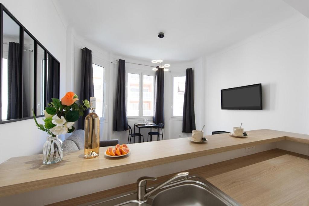 a living room with a sink and a counter with flowers at Palais athenea in Beausoleil