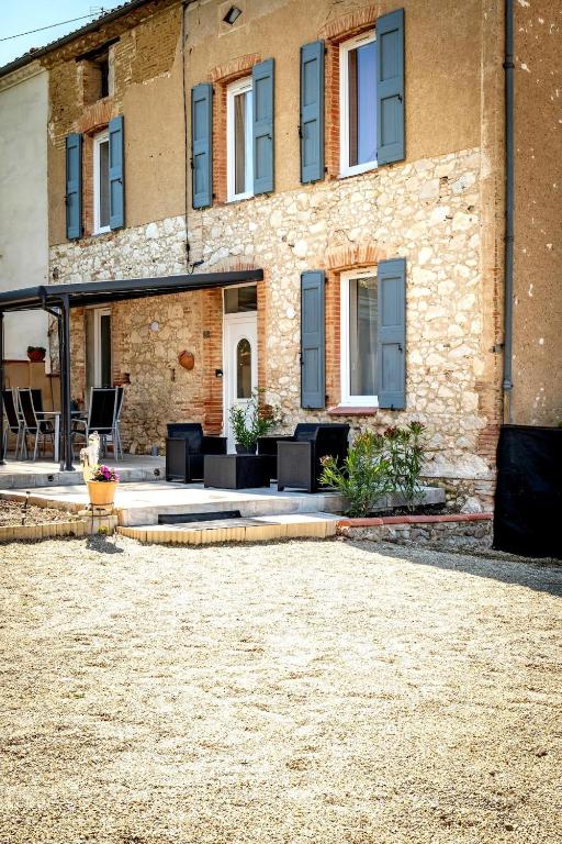 - un bâtiment avec une terrasse en face dans l'établissement Au Paradis Des Anges maison de village climatisé avec jardin, à Briatexte