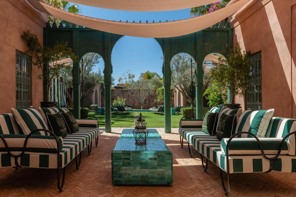 an outdoor patio with couches and a table at Luxurious Villa with private pool - Kasbah Conti in Marrakesh