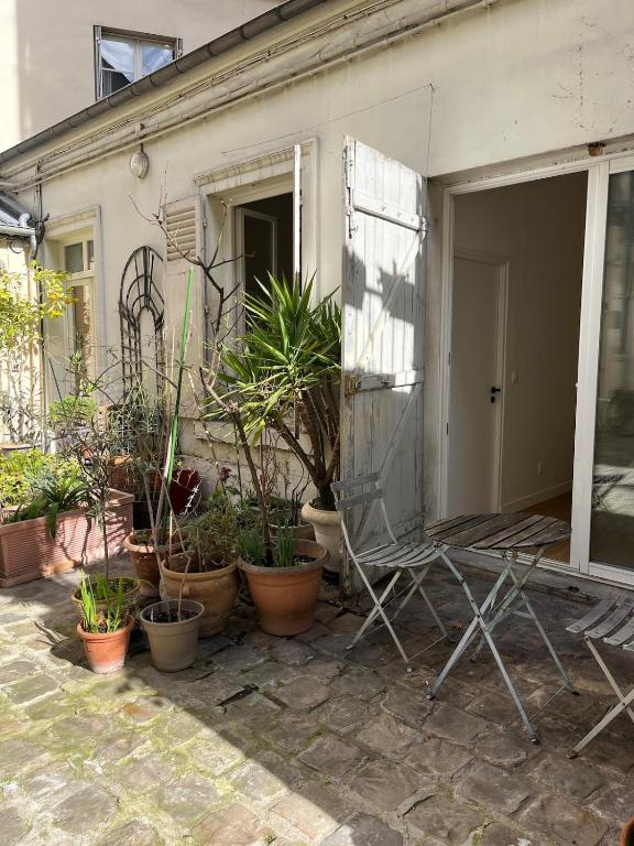 une terrasse avec un bouquet de plantes et une chaise dans l'établissement Beautiful cozy apartment, à Paris