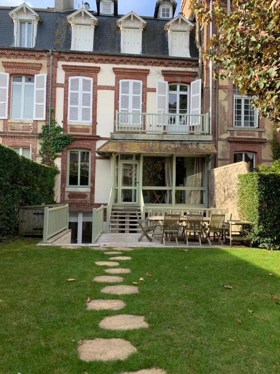- un grand bâtiment avec des chaises et des tables dans la cour dans l'établissement Appartement Deauville, à Deauville