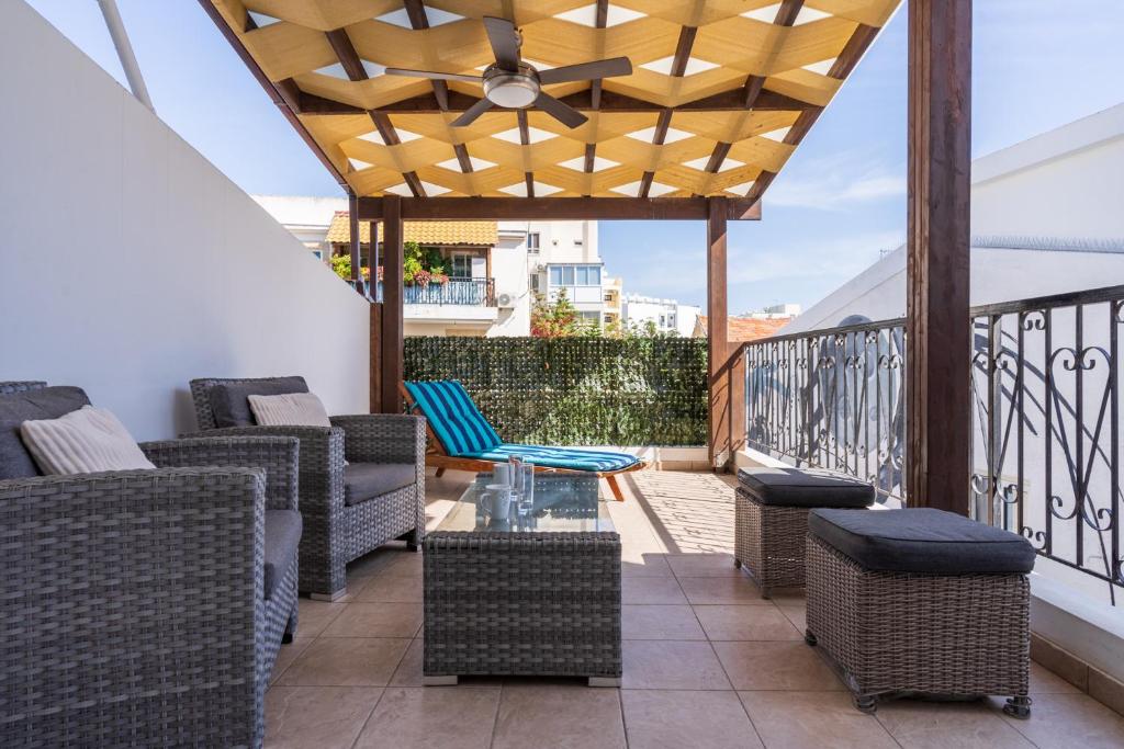 a patio with chairs and tables on a balcony at Carisa flat, 2 bedrooms in Larnaca