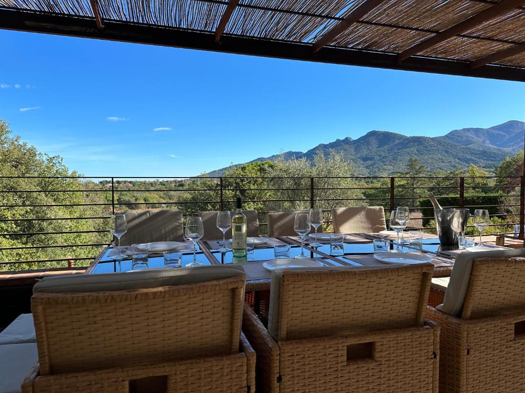 une table à manger avec des chaises et une vue sur les montagnes dans l'établissement villamahon, à Laroque-des-Albères