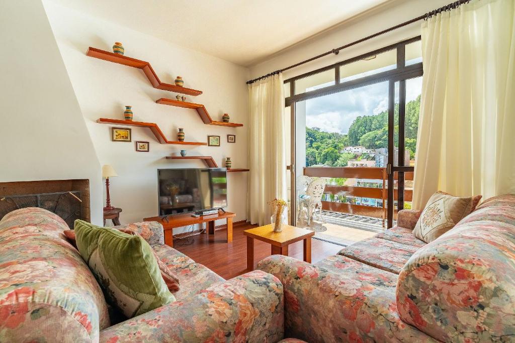 ein Wohnzimmer mit Couch und Kamin in der Unterkunft Lindo Apto no Centro de Serra Negra in Serra Negra