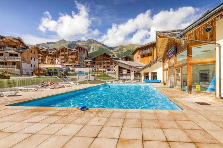 une grande piscine avec des montagnes en arrière-plan dans l'établissement Appartement 6 personnes au coeur de la station Les Orres 1800m, aux Orres