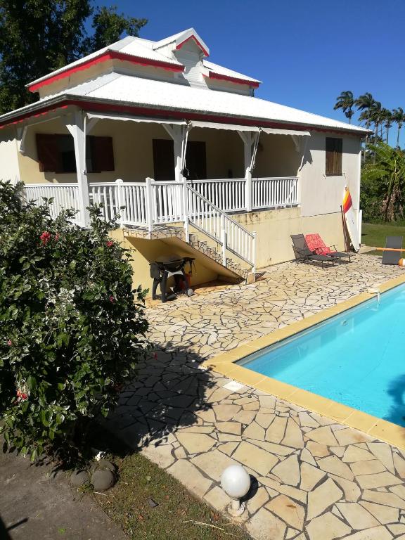 a house with a swimming pool in front of it at La maison in Sainte-Rose