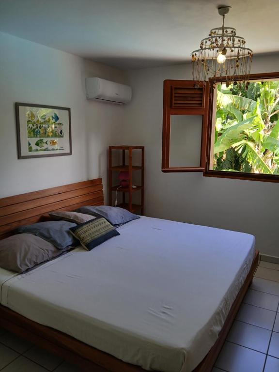 a bedroom with a large bed with a window at La maison in Sainte-Rose