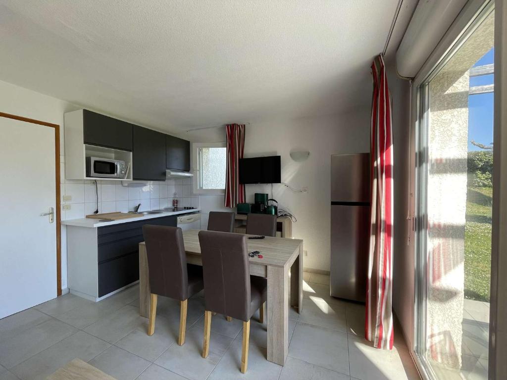 une cuisine avec une table et des chaises dans une cuisine dans l'établissement Maison duplex avec clim, 2 piscines, terrasse, parking, animaux admis - 8 pers. - FR-1-382-165, à Salavas
