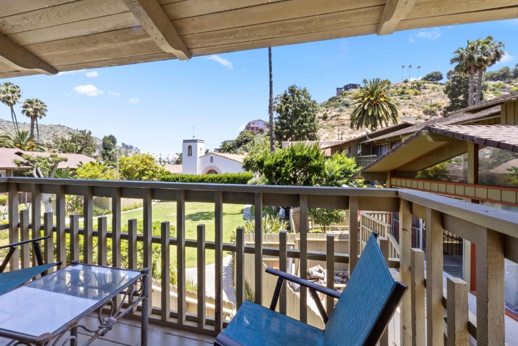 a balcony with two blue chairs and a table at 11 Canyon Terrace by Catalina Island Vacation Rentals in Avalon