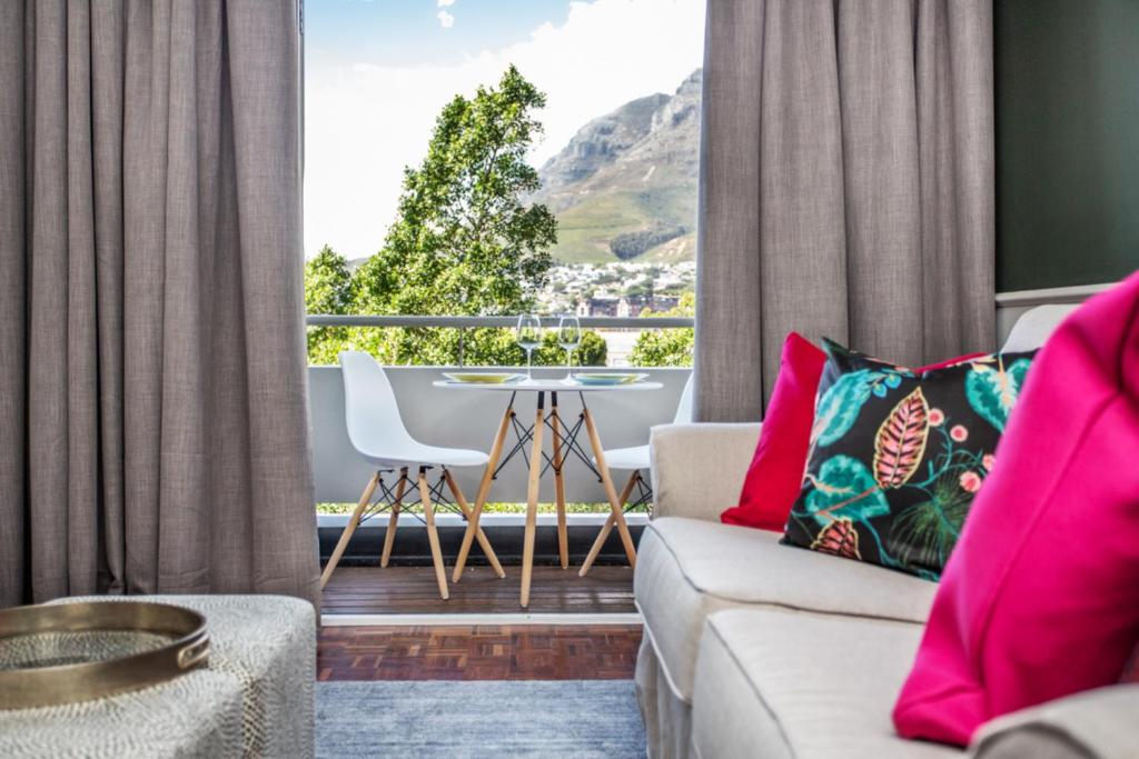 een woonkamer met een bank en een tafel bij St Martini Mountain View Studio in Kaapstad