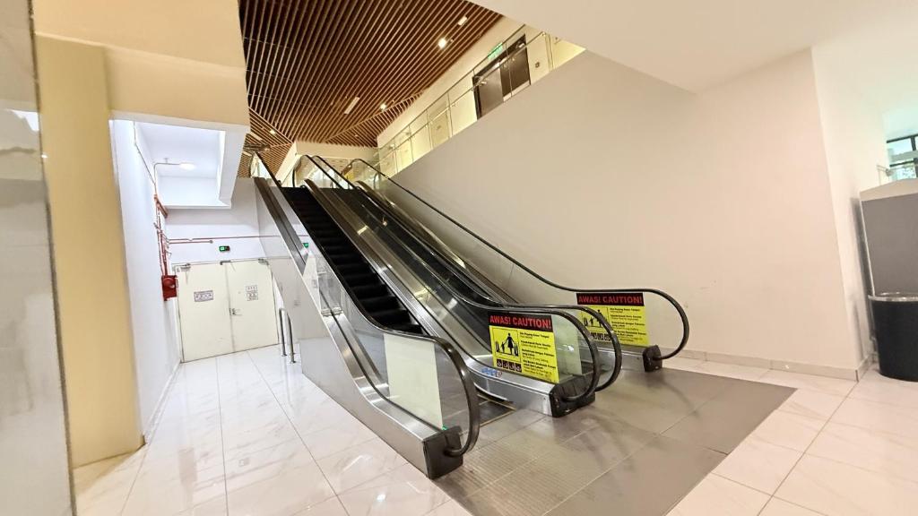 an escalator in a building with a baggage claim at Colony Service Suites Kuala Lumpur in Kuala Lumpur