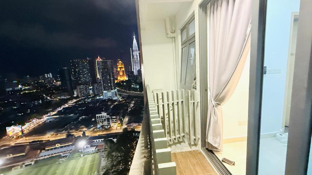 a balcony with a view of a city at night at Colony Service Suites Kuala Lumpur in Kuala Lumpur