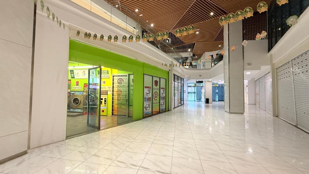 an empty hallway in a building with a green wall at Colony Service Suites Kuala Lumpur in Kuala Lumpur