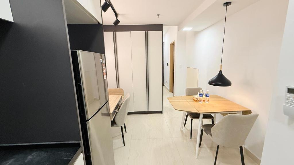 a kitchen and dining room with a table and a refrigerator at Colony Service Suites Kuala Lumpur in Kuala Lumpur