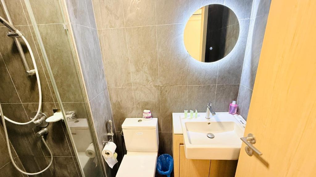 a bathroom with a sink and a toilet and a mirror at Colony Service Suites Kuala Lumpur in Kuala Lumpur