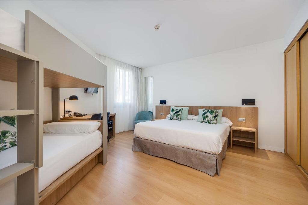 a hotel room with two beds and a desk at Daniya Alicante in Alicante