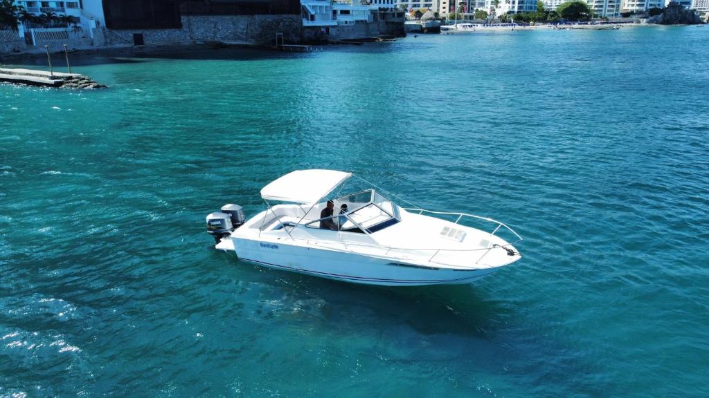 a white boat in a body of water at lancha deportiva stand by me in Rodadero