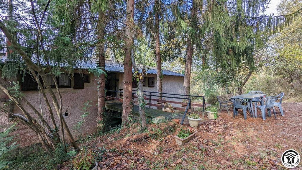a house with a table and chairs in the woods at L'ouastadet in Aspret-Sarrat