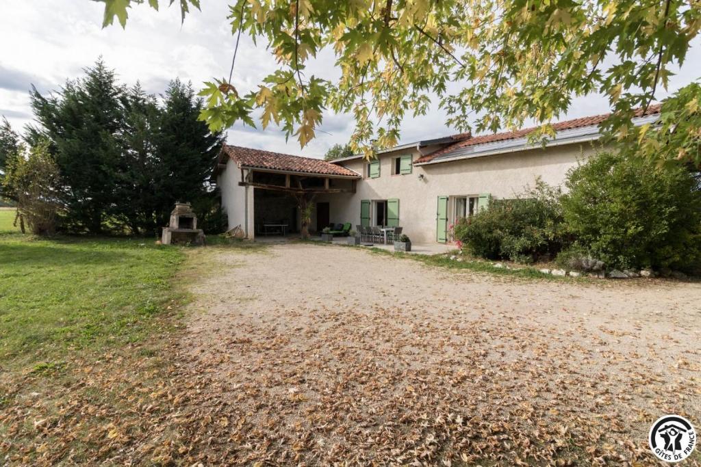 a house with a gravel driveway in front of it at La lande in Ponlat-Taillebourg