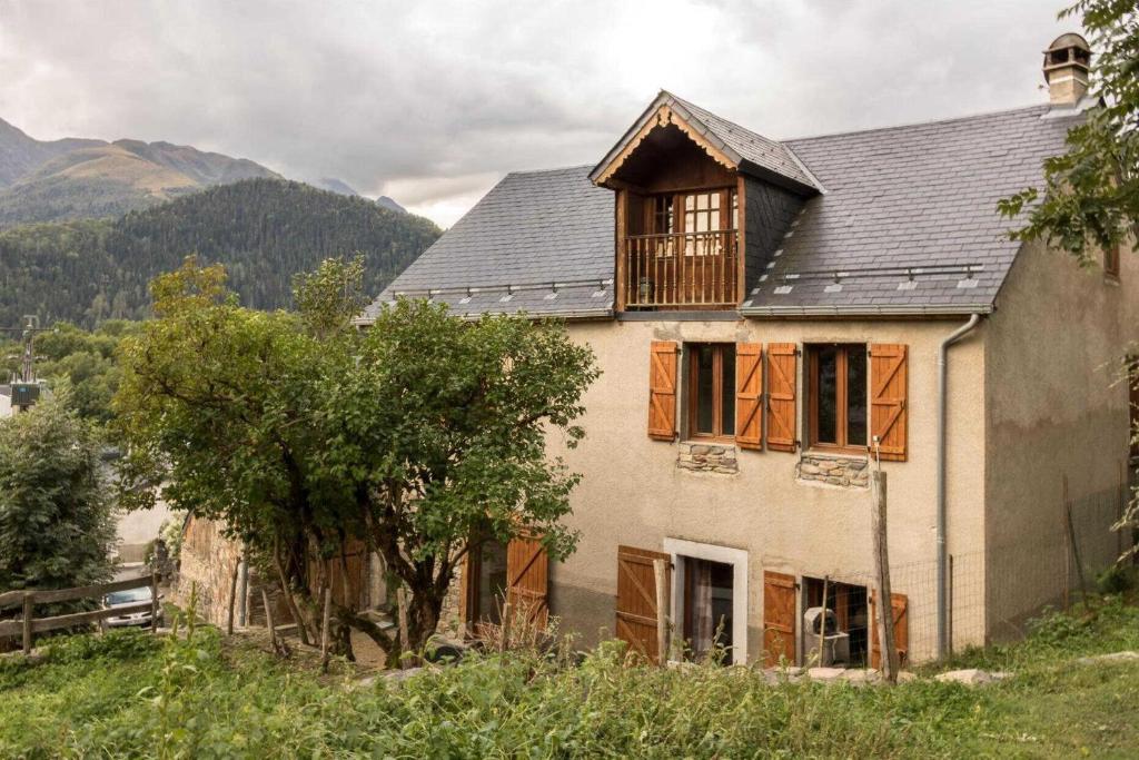 a house with a gambrel roof on a hill at Près de l'eglise in Garin