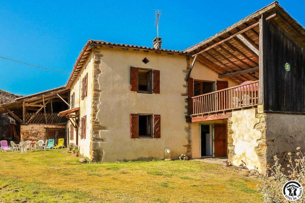 ein altes Haus mit einem Balkon an der Seite in der Unterkunft Panifous in Montbrun-Bocage