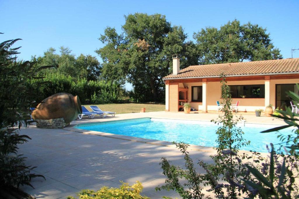 a house with a swimming pool in front of a house at Le petit clot de pey in Esperce