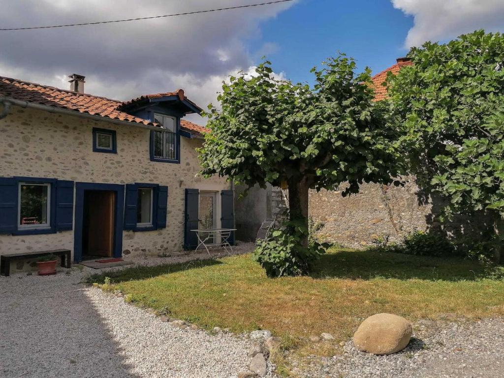 a house with a tree in front of it at Le gar in Labarthe-Rivière