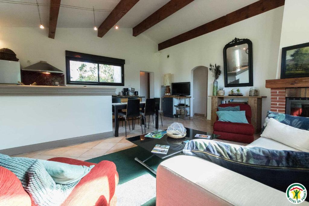 a living room with a couch and a table at En sales in Saint-Jean-Lherm