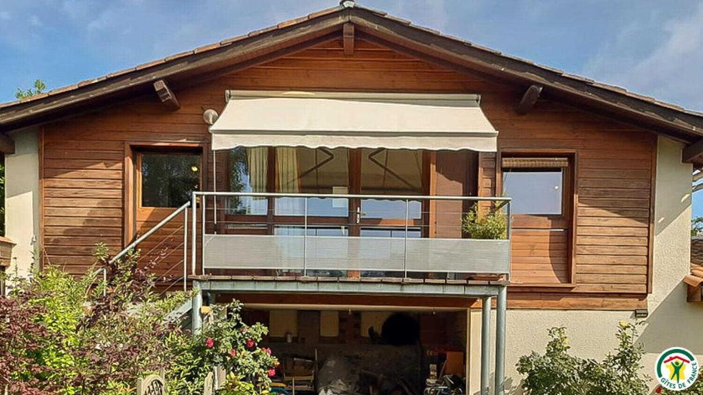 a house with a balcony on the front of it at Framboisine in Cazères