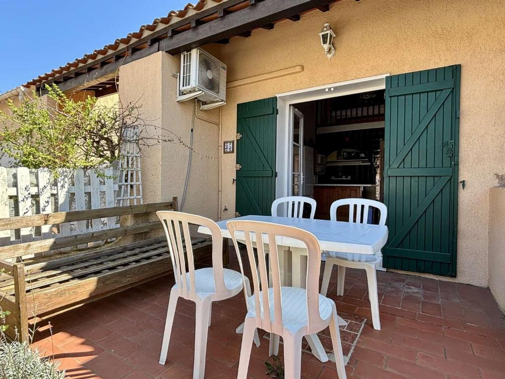 stół i krzesła na patio z zielonymi drzwiami w obiekcie Maison T3 avec mezzanine, piscine, parking, proche mer - Argelès-sur-Mer - FR-1-225-774 w Argelès-sur-Mer
